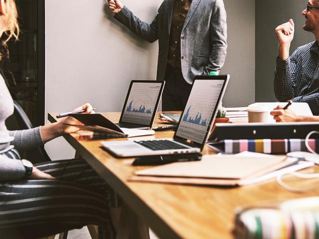 group looking at colleague present something on a white board